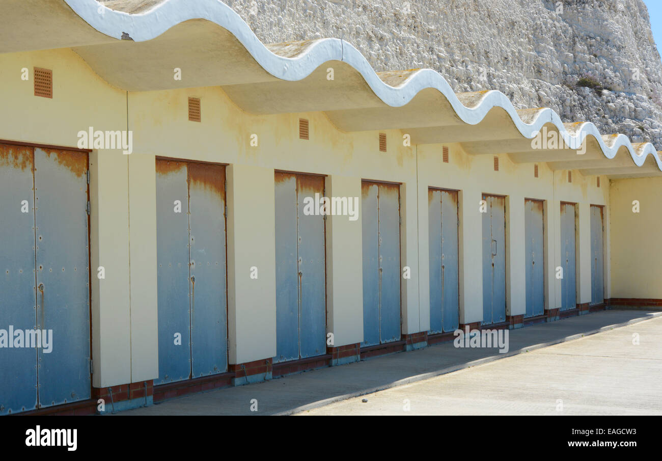 Old concrete beach huts built into chalk cliff base at Rottingdean near Brighton in East Sussex. England Stock Photo