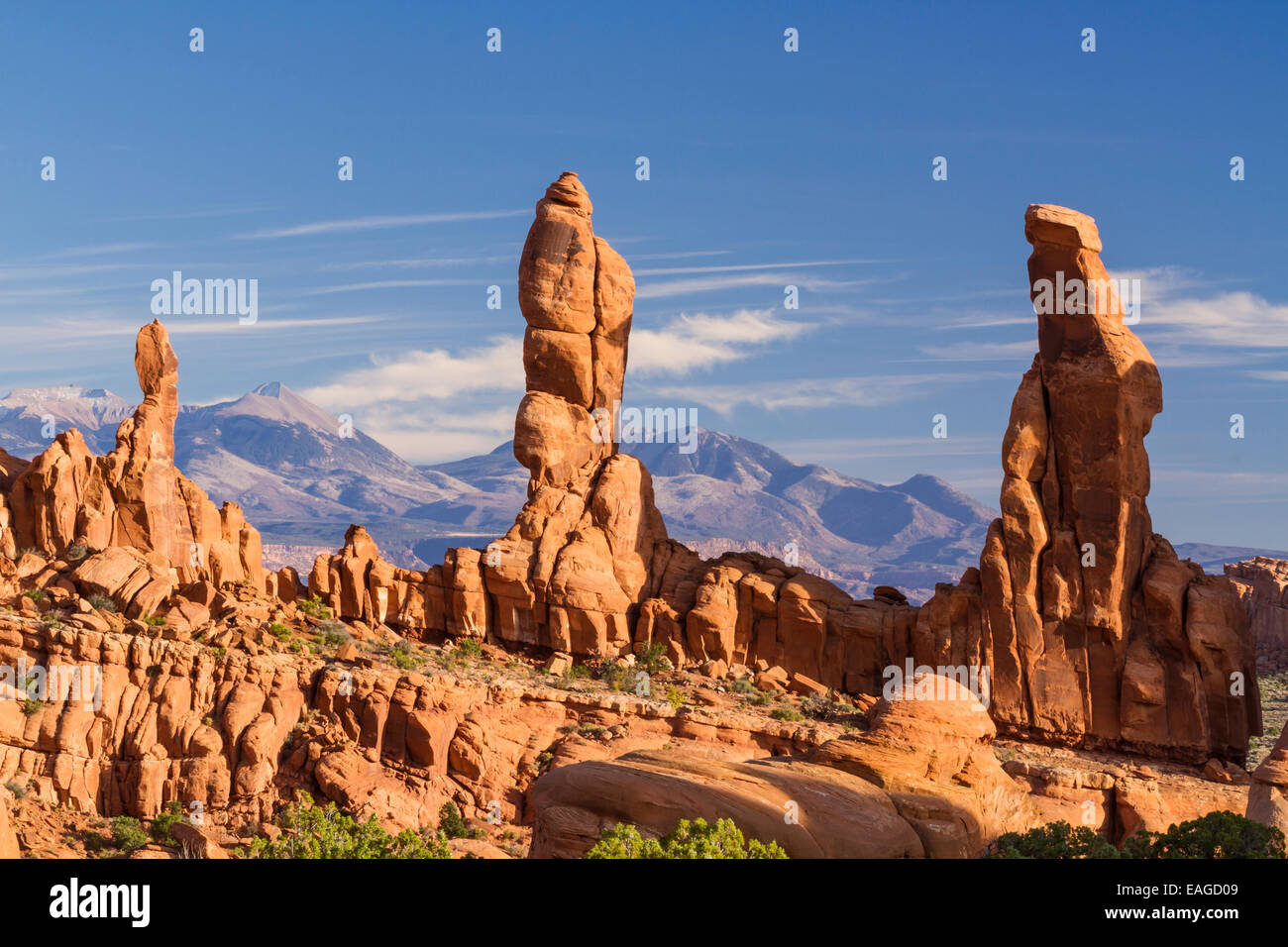 Three 'Marching Men' sandstone pillars in front of the La Sal Mountains in the Klondike Bluffs area of Arches National Park, Uta Stock Photo