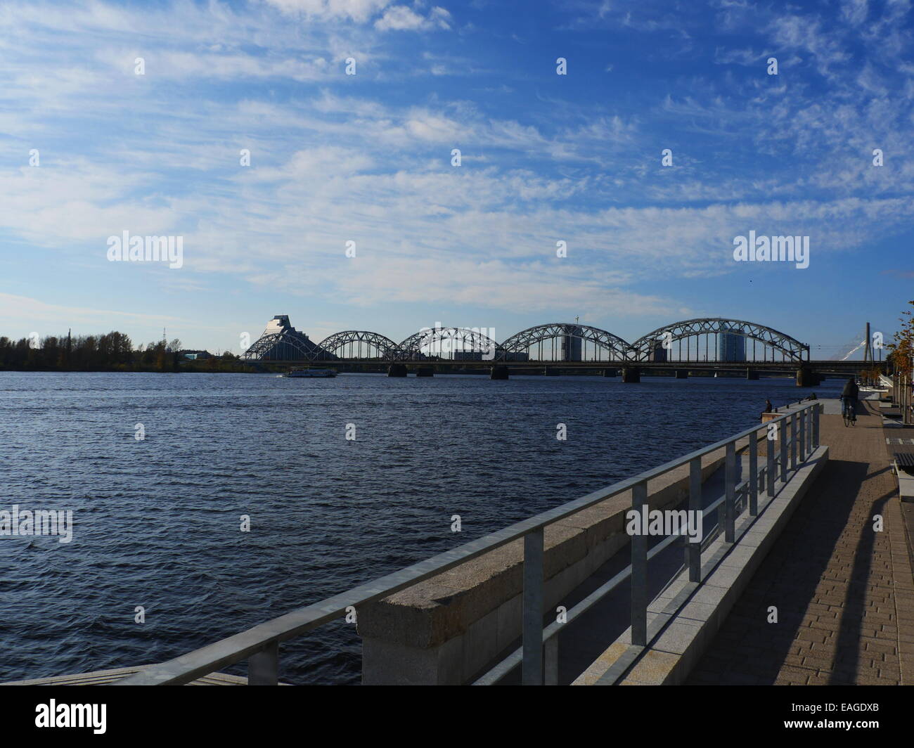 boat crossing railroad bridge and National Library in Riga Stock Photo