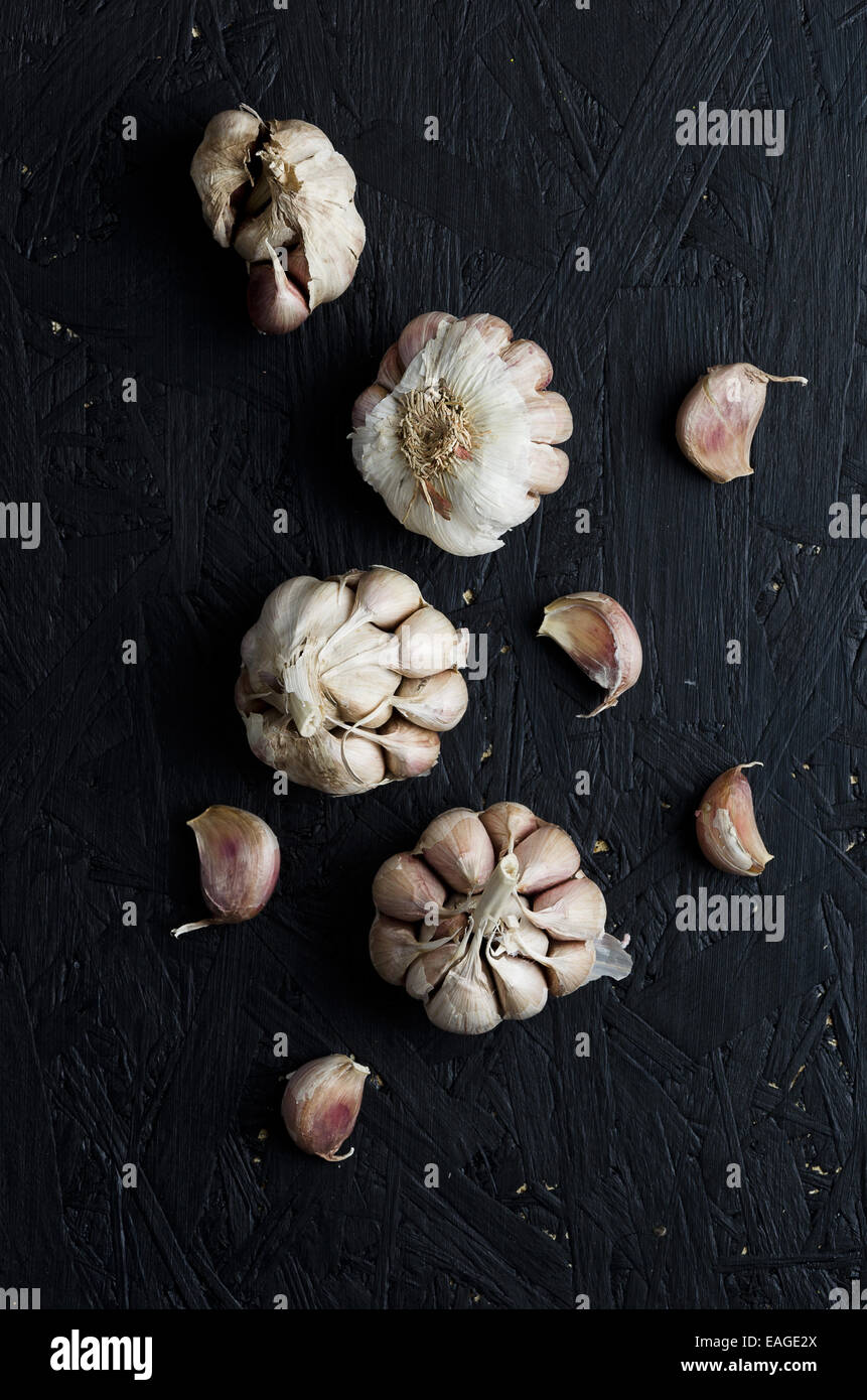 Cloves of garlic over dark black sawdust table Stock Photo - Alamy