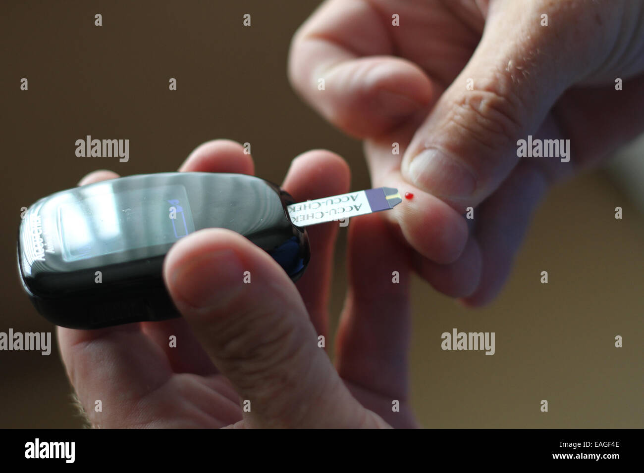 A diabetic man testing his blood glucose levels Stock Photo