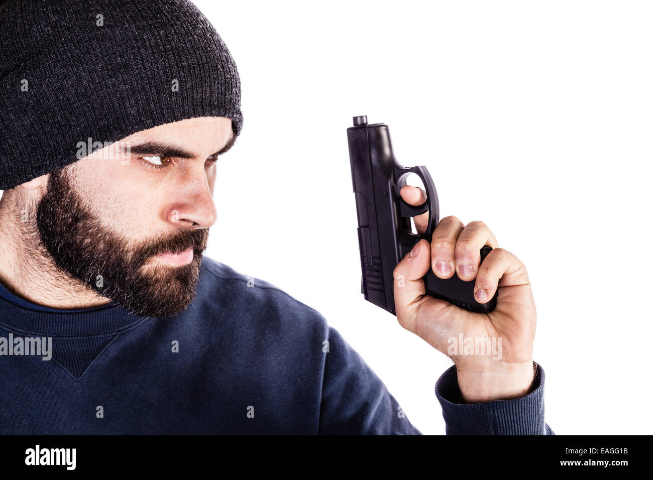 a bearded criminal or an undercover cop with a pistol and wearing a beanie hat isolated over white Stock Photo