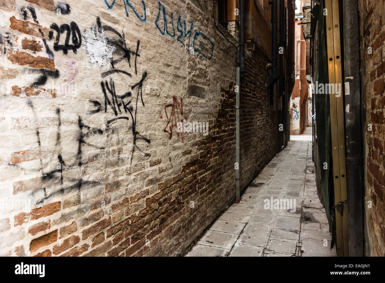 a narrow and dirty alley with graffiti in Venice, Italy Stock Photo