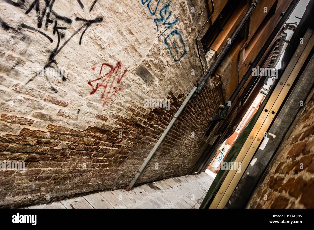 a narrow and dirty alley with graffiti in Venice, Italy Stock Photo