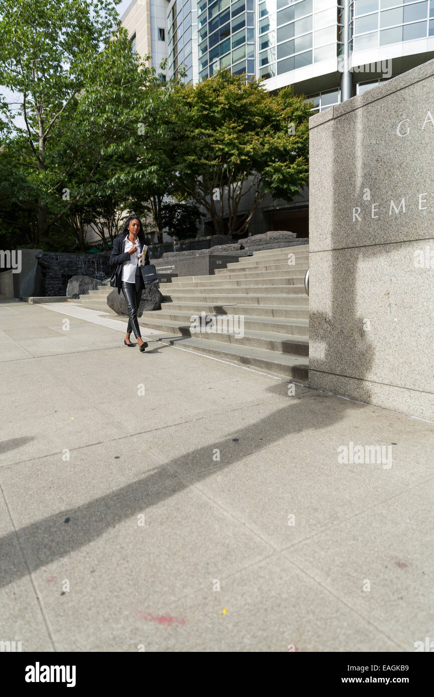 Young professional woman walking along the sidewalk / near stairs Stock Photo