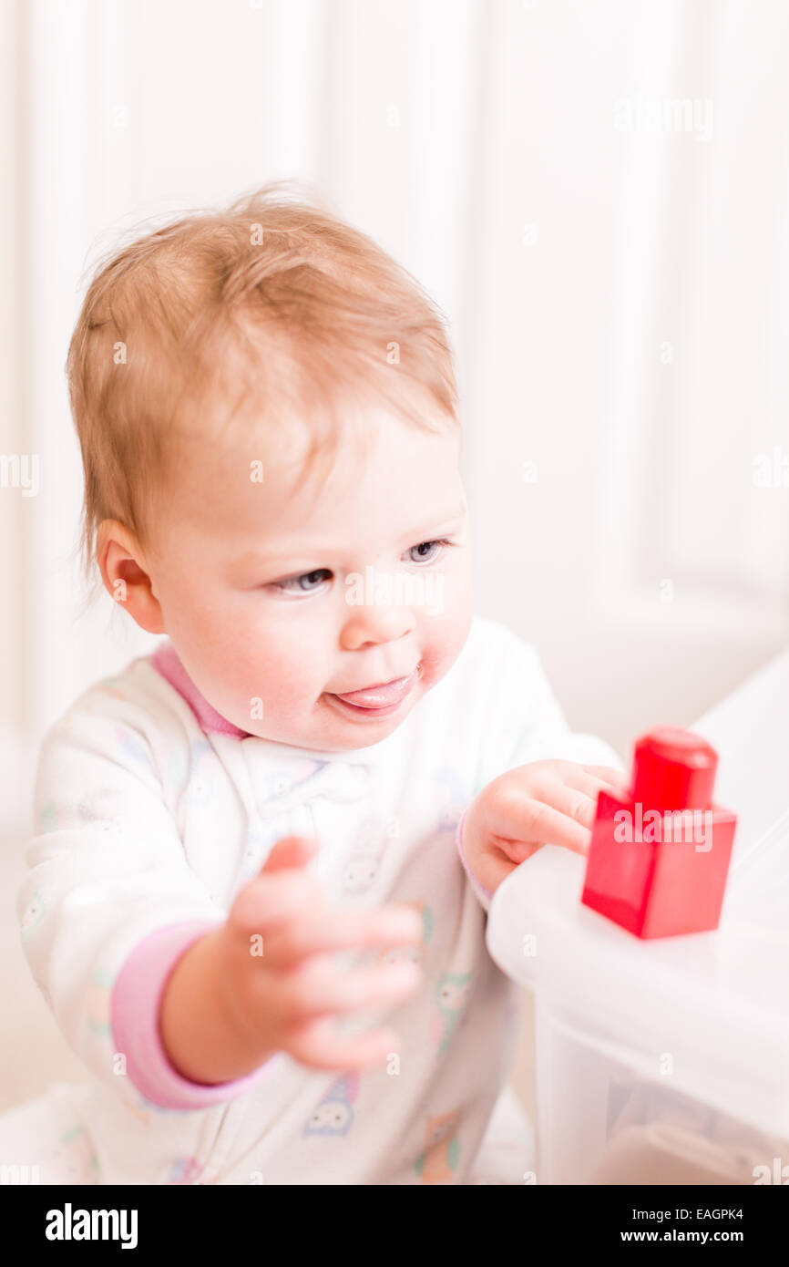 Cute baby girl playing with cubes on the floor Stock Photo Alamy