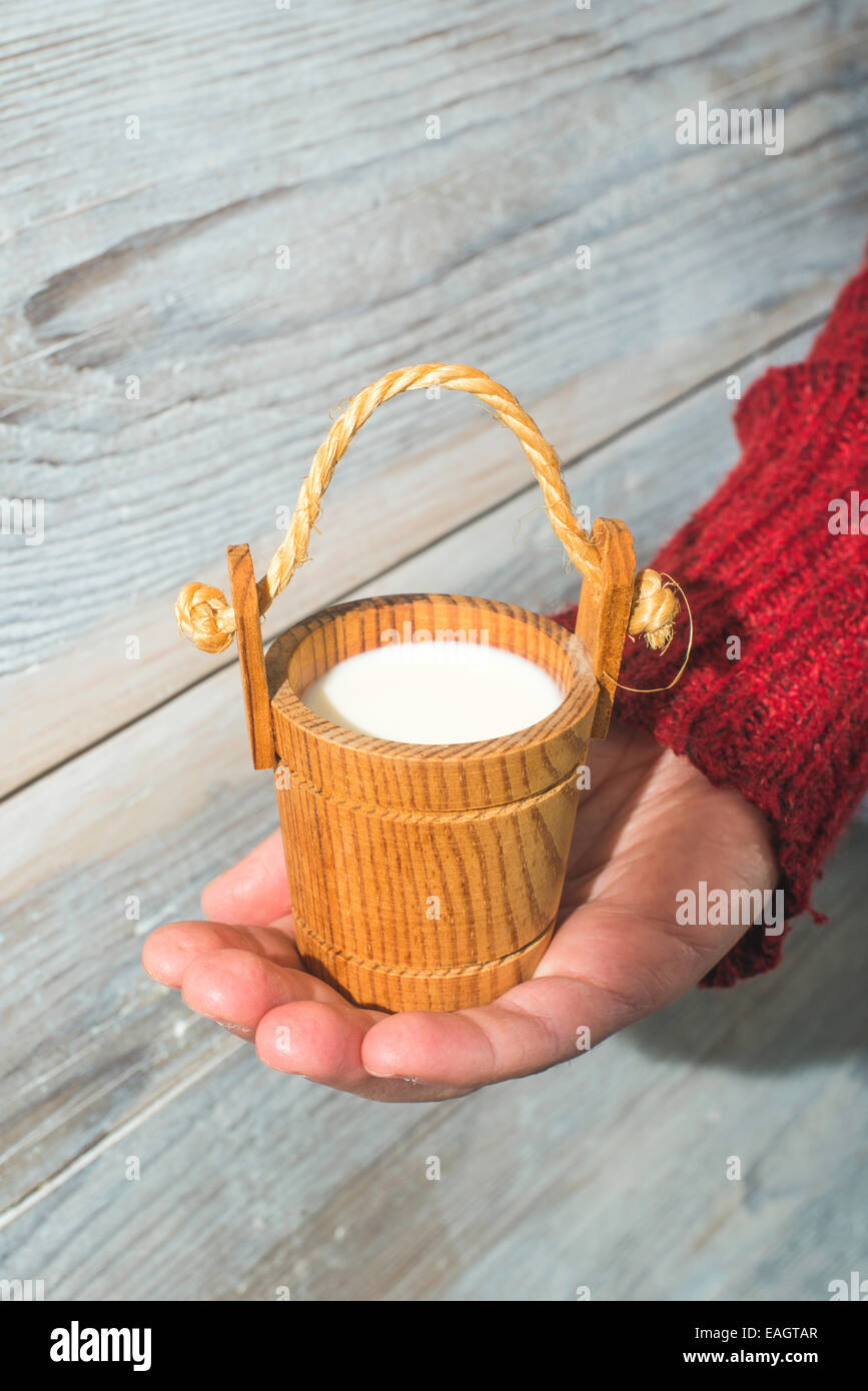 Vintage small wooden mug of milk Stock Photo