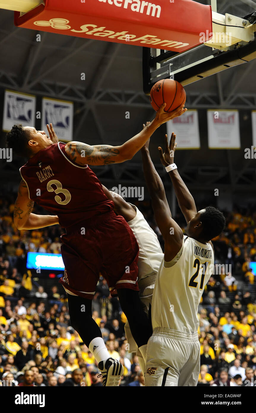 Wichita, Kansas, USA. 14th Nov, 2014. New Mexico State Aggies forward Remi Barry (3) is fouled by Wichita State Shockers center Tom Wamukota (21) in 2nd half action during the NCAA Basketball game between the New Mexico State Aggies and the Wichita State Shockers at Charles Koch Arena in Wichita, Kansas. Kendall Shaw/CSM/Alamy Live News Stock Photo