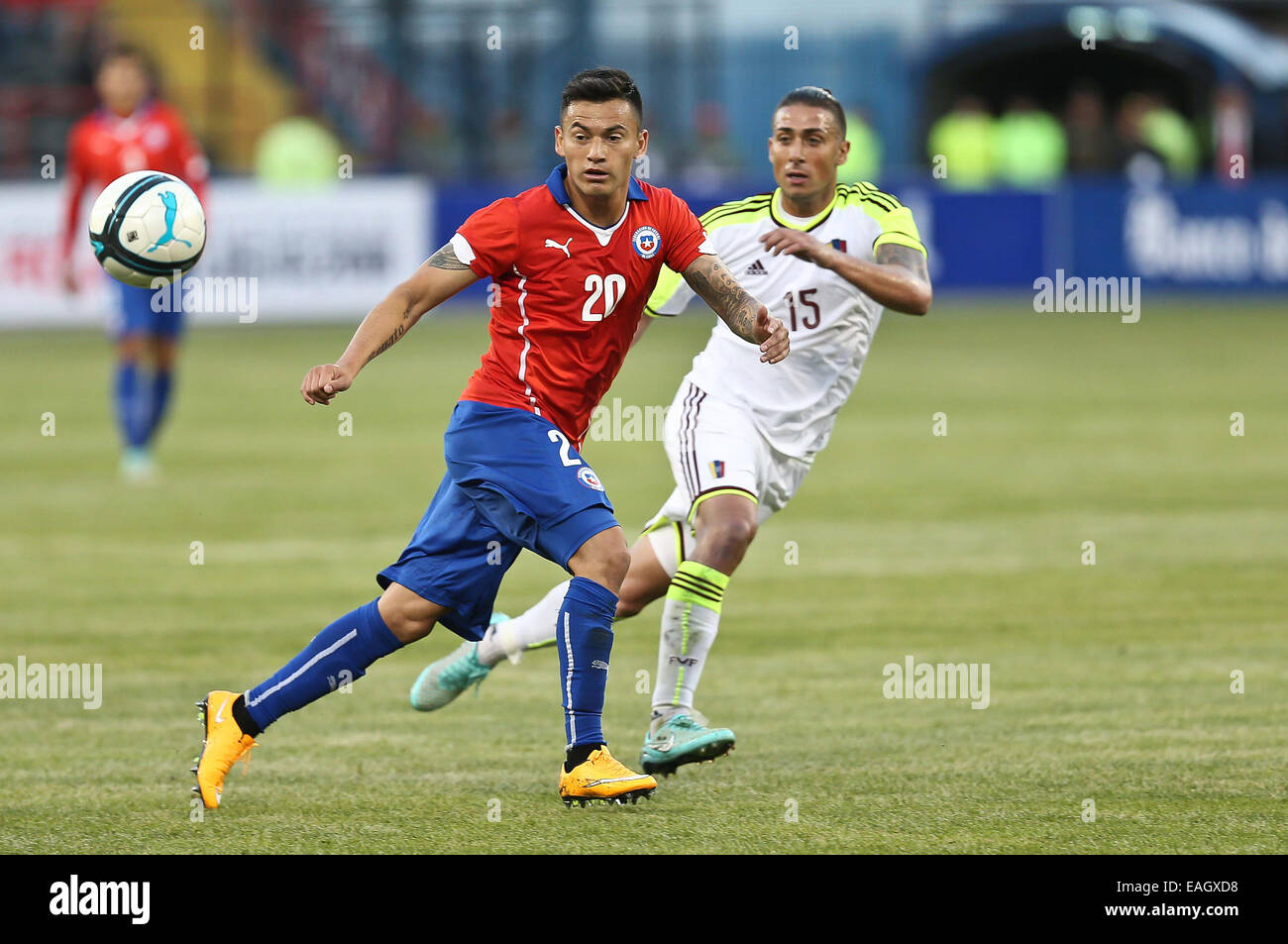 Talcahuano, Chile. 14th Nov, 2014. Image provided by the National Asociation of Professional Soccer shows Chile's Charles Aranguiz (L) vying with Venezuela's Rafael Acosta during a friendly match in Talcahuano, Chile, Nov. 14, 2014. © ANFP/Xinhua/Alamy Live News Stock Photo