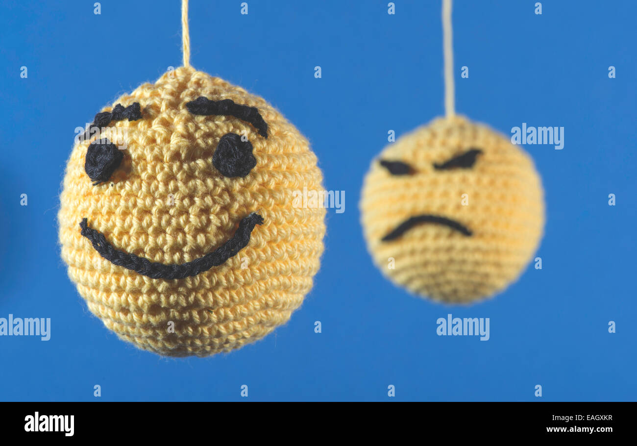 Knitted yellow emoticons on blue background Stock Photo
