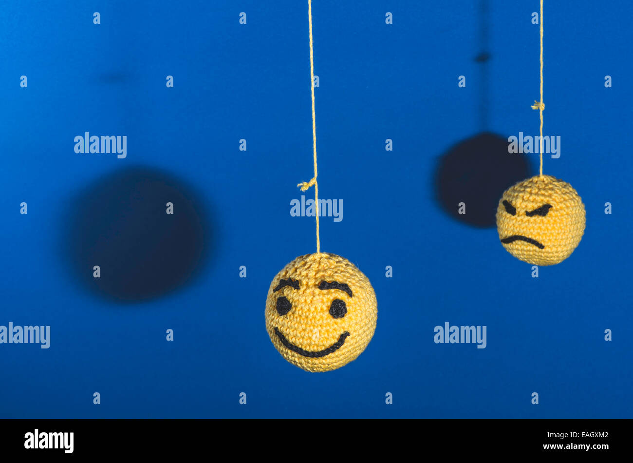 Knitted yellow emoticons on blue background Stock Photo