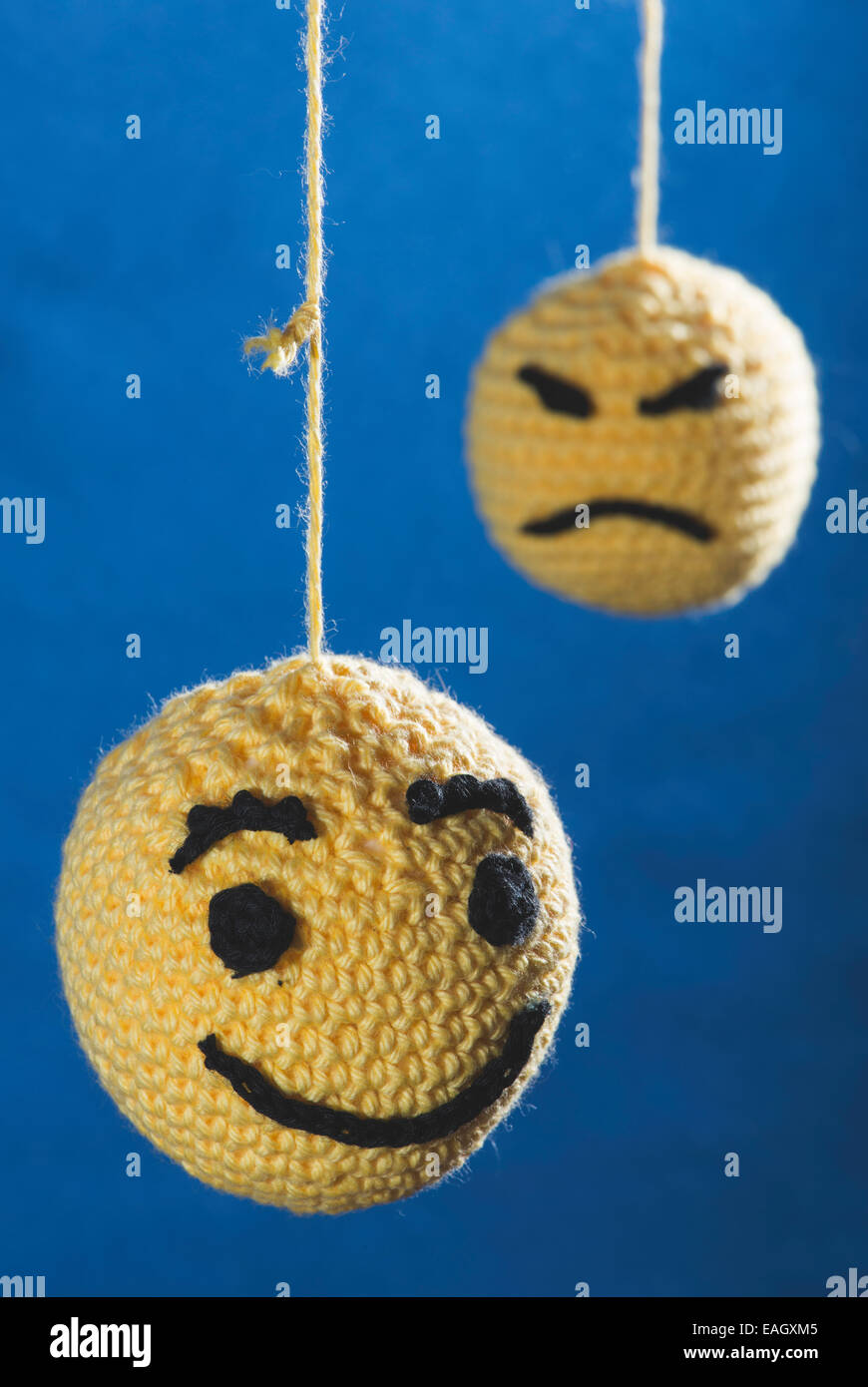 Knitted yellow emoticons on blue background Stock Photo