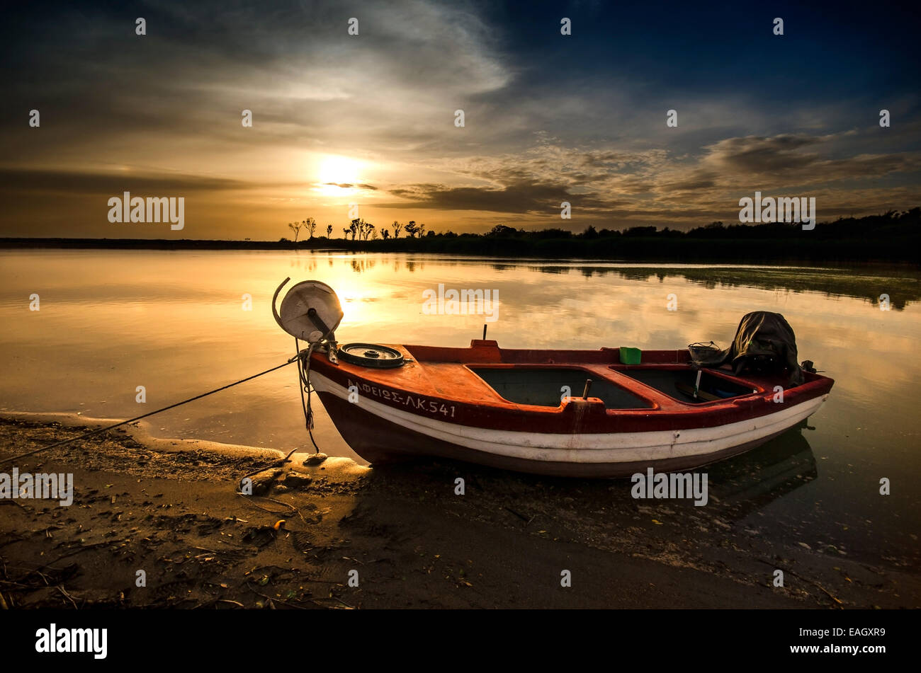 The red fishing boat at sunset on Greece Stock Photo