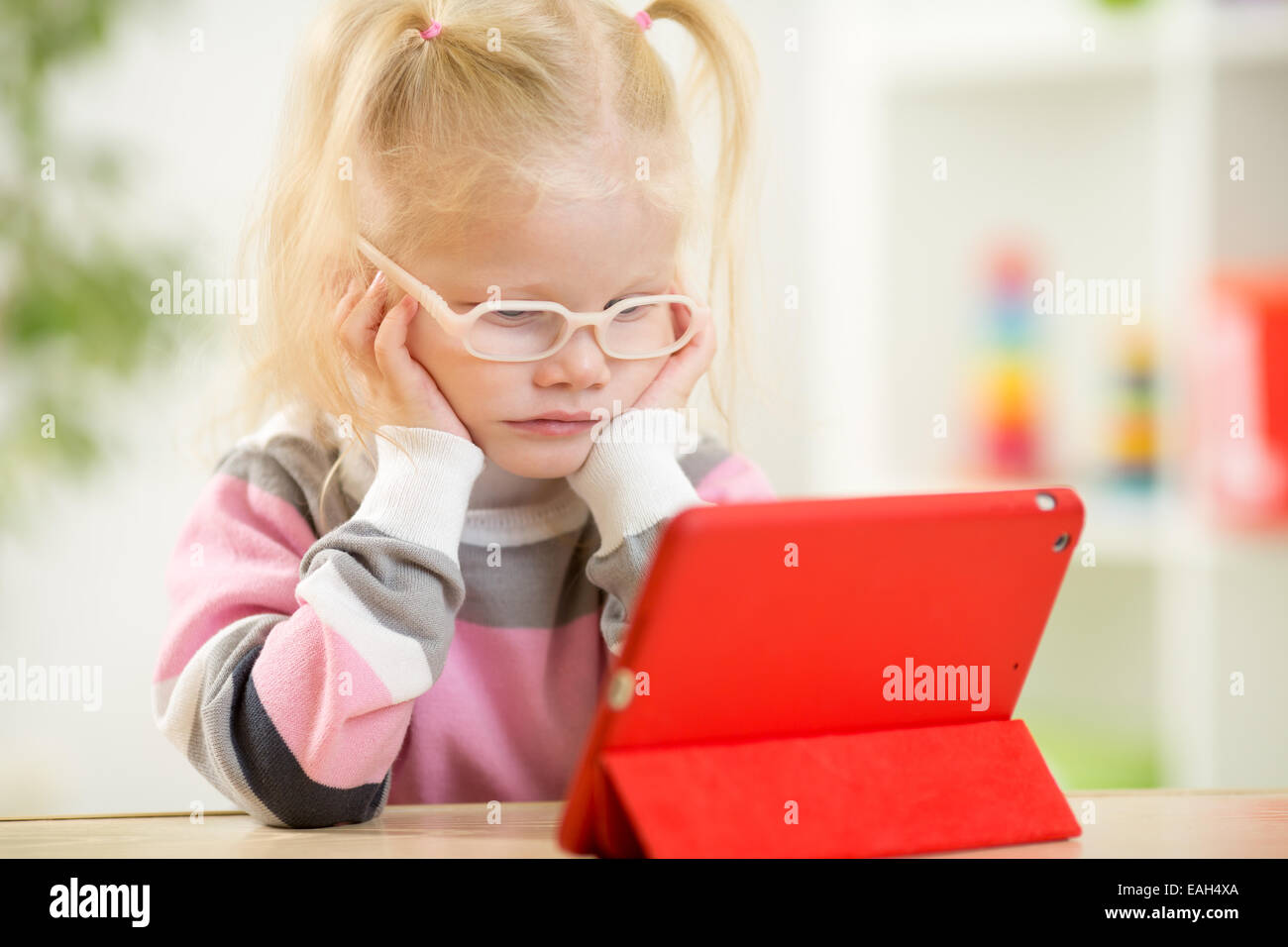 happy child in glasses looking at mini tablet pc screen Stock Photo