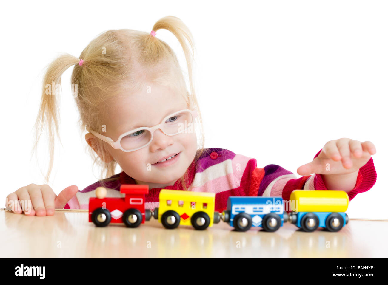 Kid in eyeglases playing toy train isolated Stock Photo