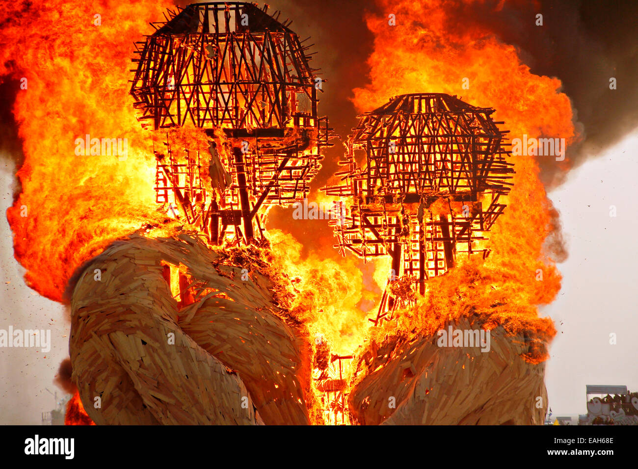The art installation Embrace is set on fire on the playa at the annual Burning Man festival in the desert August 29, 2014 in Black Rock City, Nevada. Stock Photo