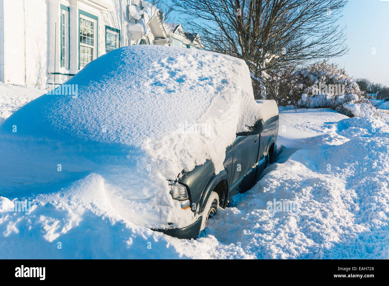 A quart ton truck buried under snow in a suburban driveway. Stock Photo