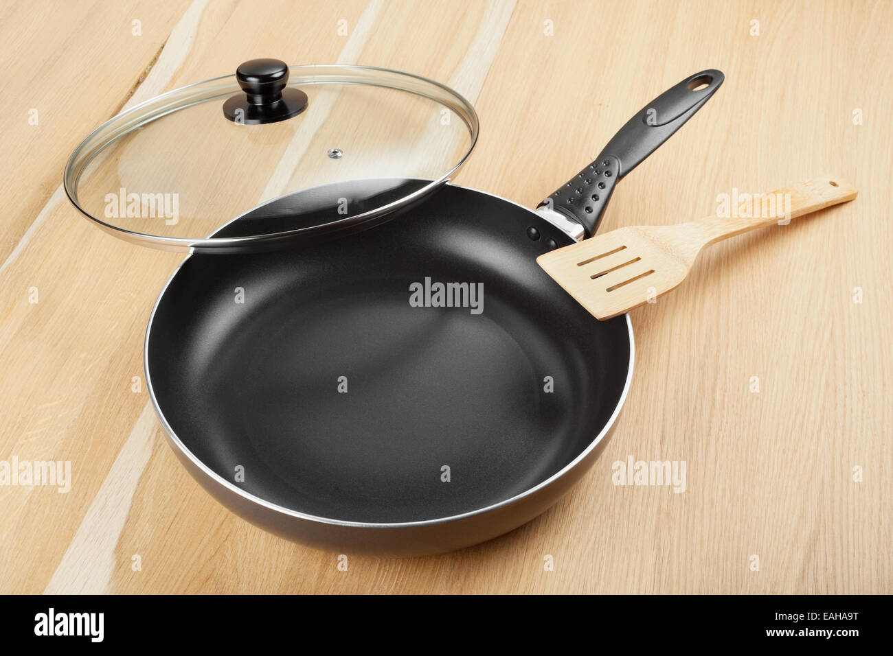 frying pan with lid on wooden table Stock Photo