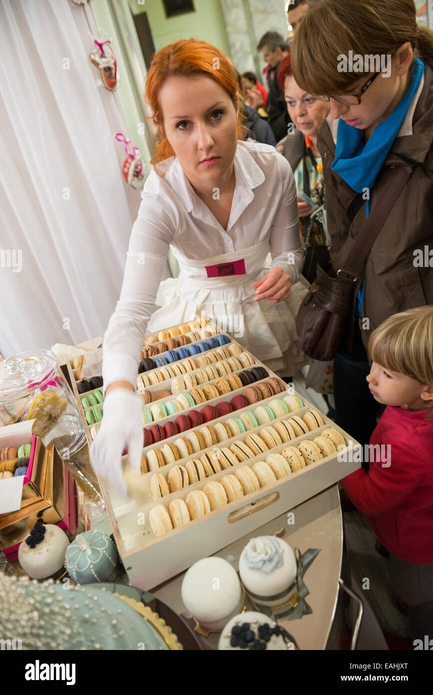 Warsaw, Poland. 15th November, 2014. Woman sells macaron - French sweet meringue-based confection displayed on a stand during the International Chocolate and Sweets Festival at the Palace of Culture and Science in Warsaw, Poland Credit:  kpzfoto/Alamy Live News Stock Photo
