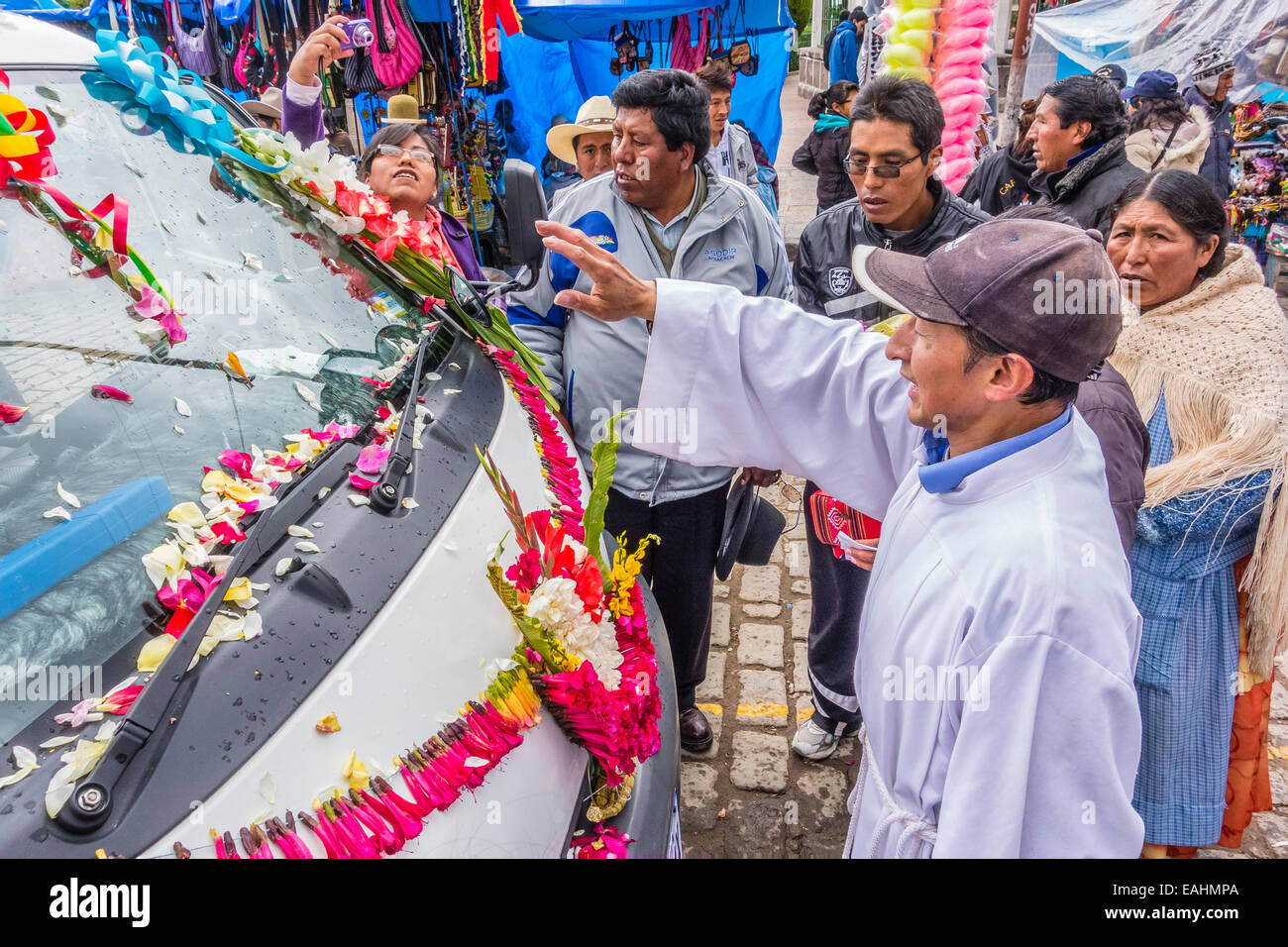 A Catholic priest blesses a van decorated for the annual blessing of the vehicles at the main cathedral in Copacabana, Bolivia. Stock Photo