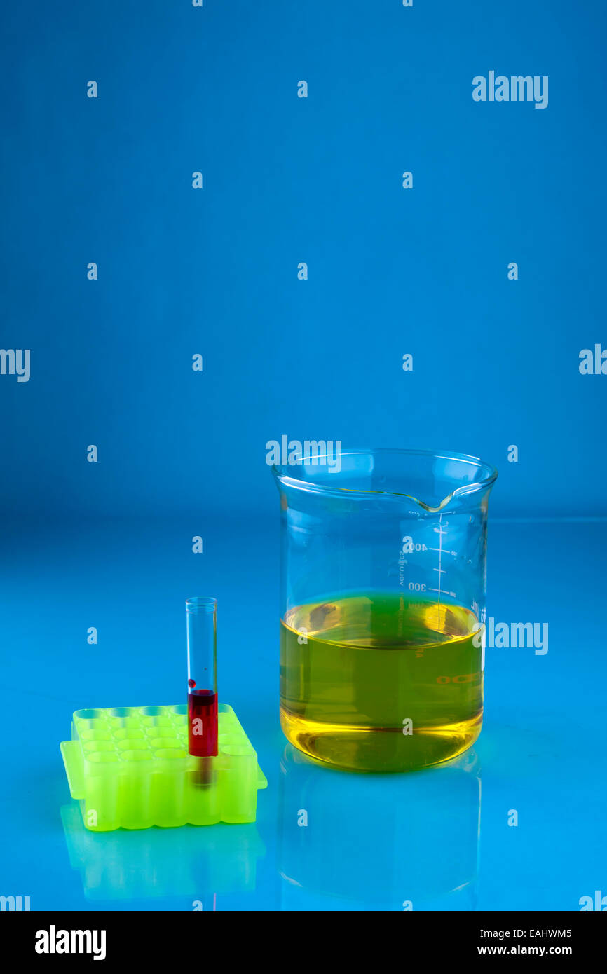 Beaker with a yellow liquid and a test tube with a red liquid Stock