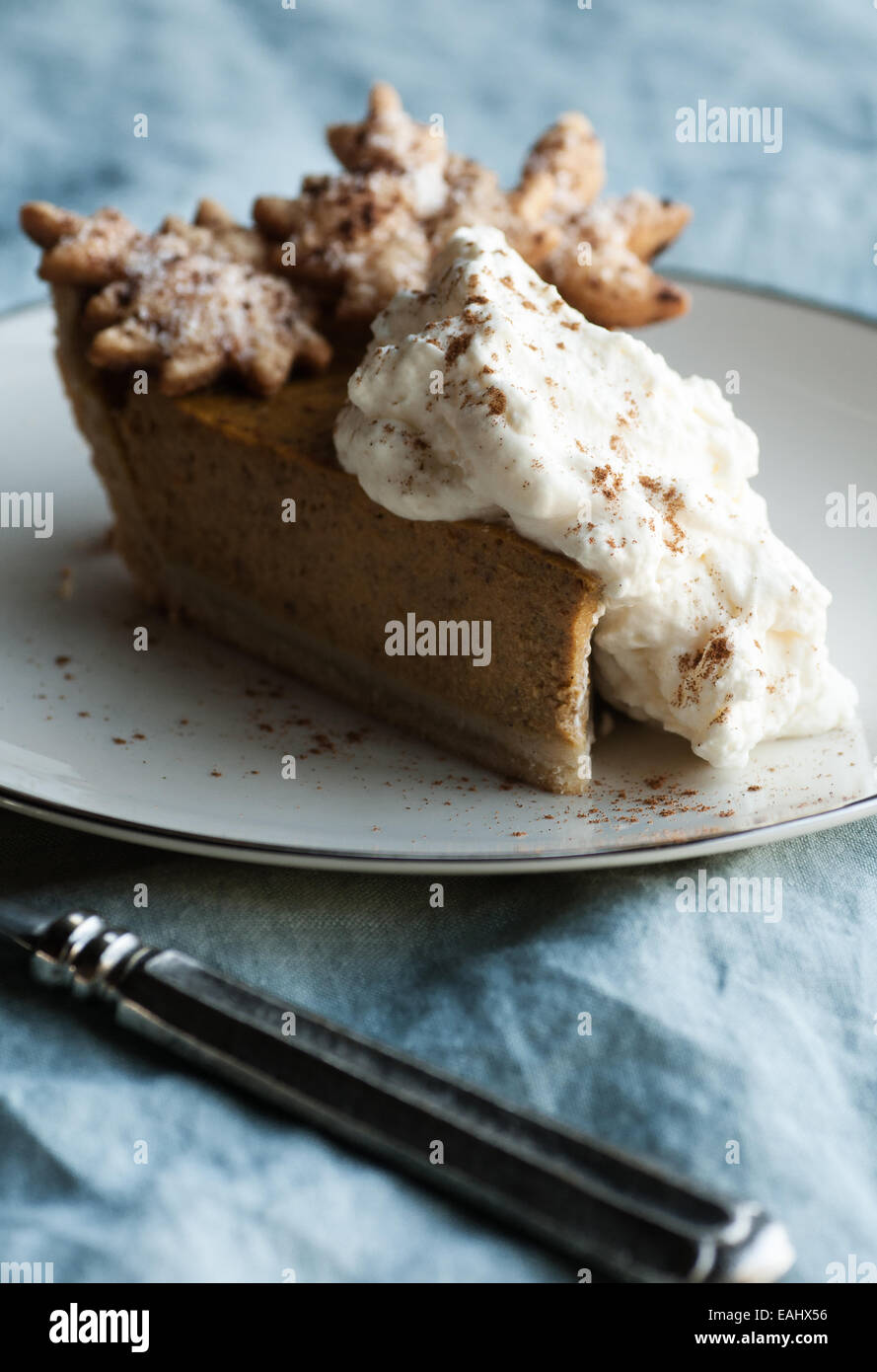 Gorgeous slice of pumpkin pie with autumn leaf pastry and whipped cream with cinnamon Stock Photo