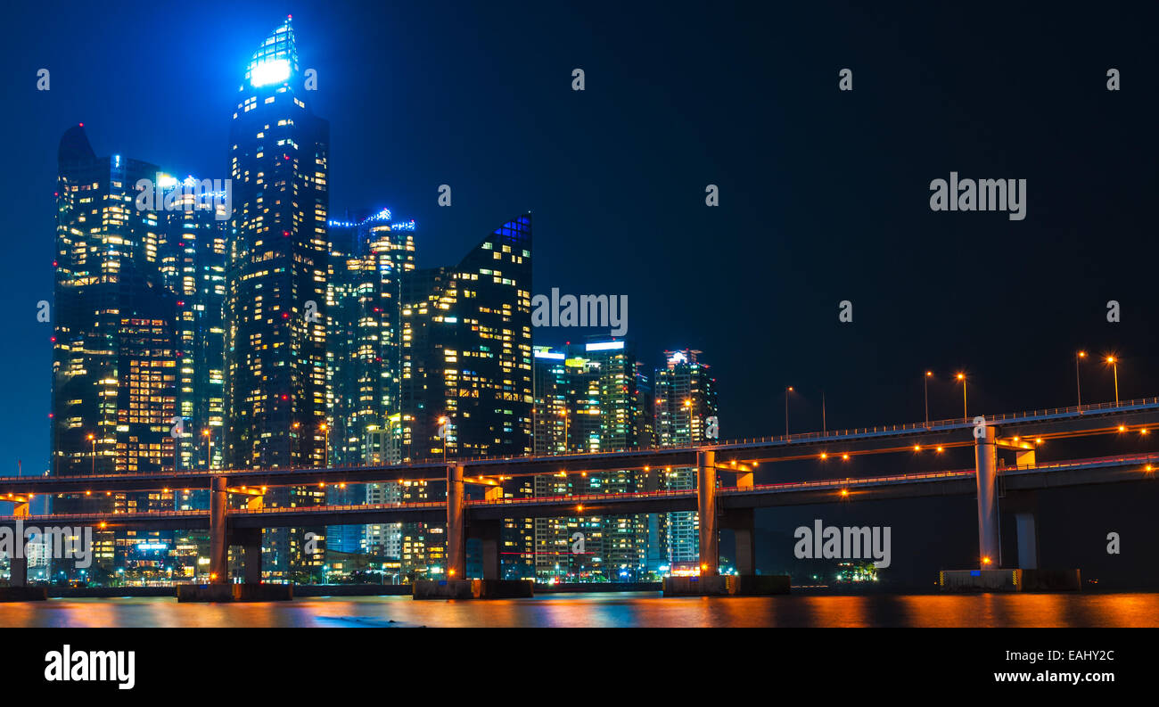 The skyline of Busan lit up at night, with Gwangan Bridge in the foreground. Stock Photo