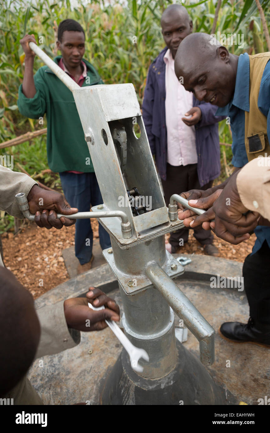 Community members in Sukuroi village, Bukwo District, Uganda work to construct a shallow well in their community. Stock Photo