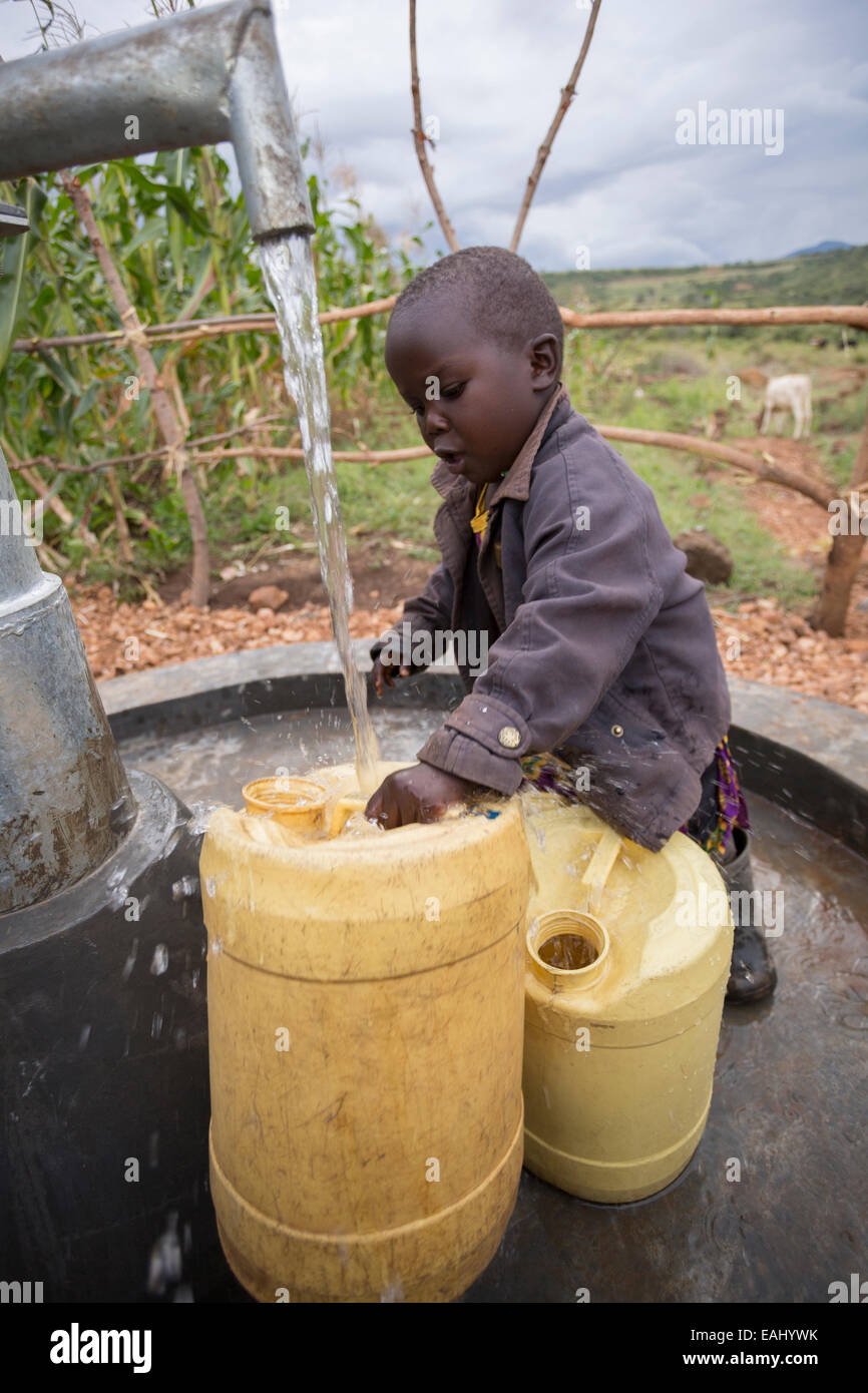 Three year-old Abigail Chemtai is the first to draw water from a newly installed well in Sukuroi village, Bukwo District, Uganda Stock Photo