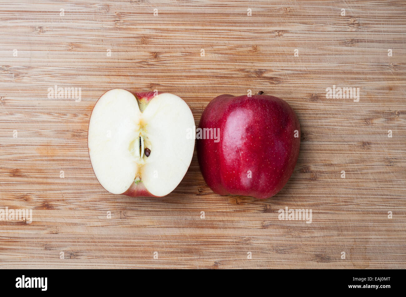 Fresh apple sliced in half on a wood board Stock Photo