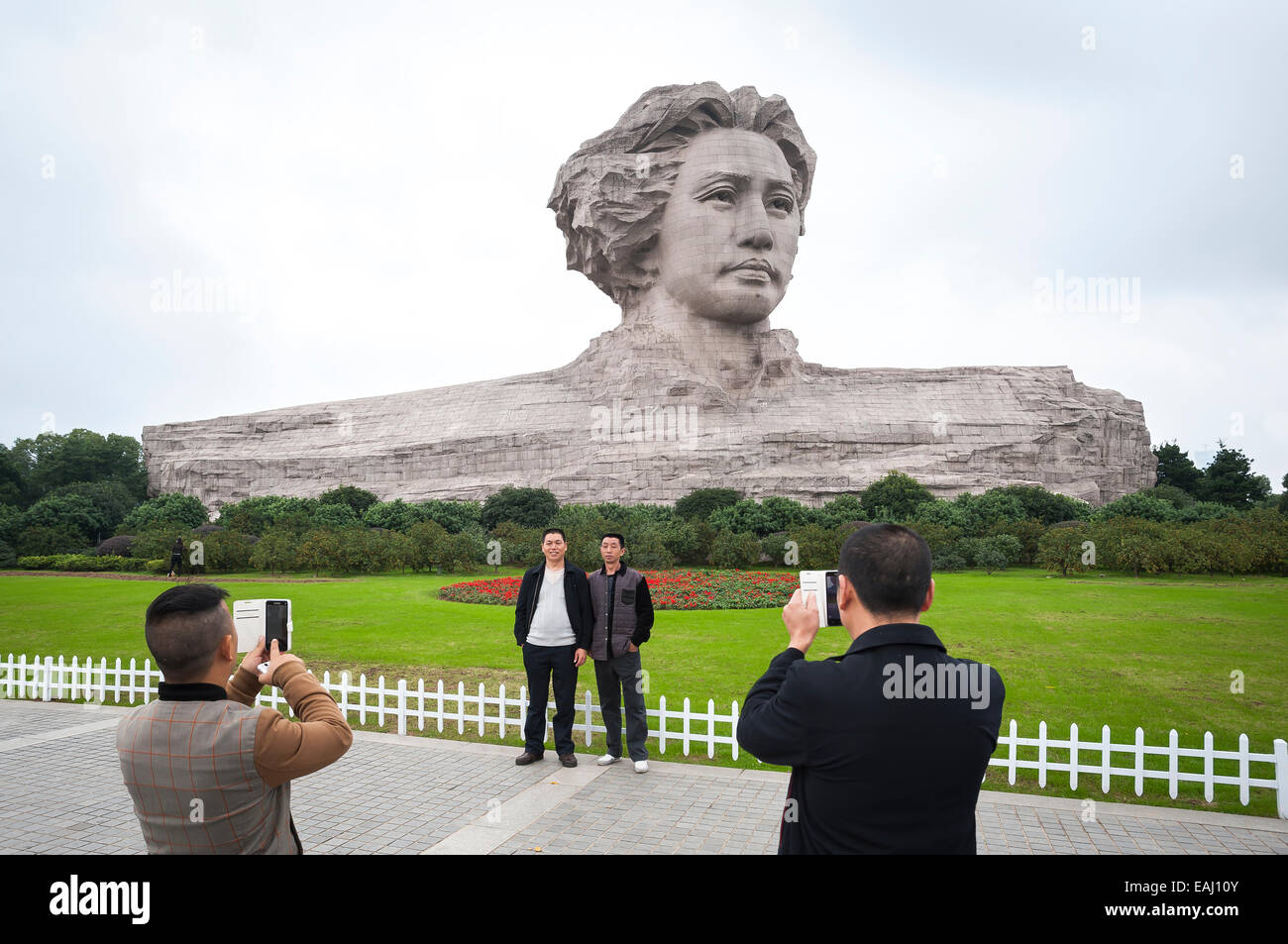 Chinese tourists pose in front of the world's largest statue of Mao Zedong in Changsha, China Stock Photo