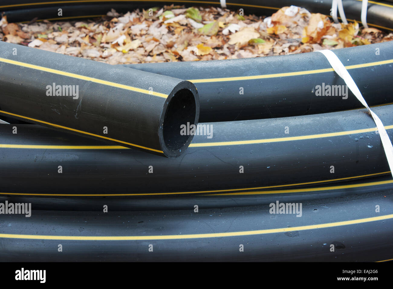 scroll black plastic sewer pipe prepared for repair outside Stock Photo