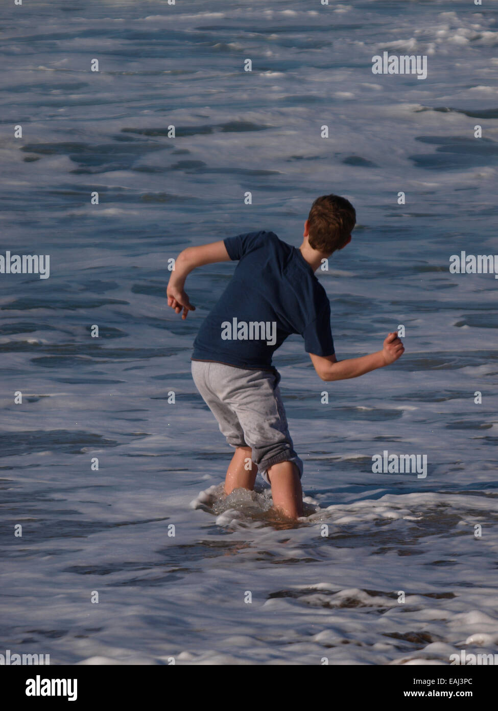 Boy skimming stones in the sea, Bude, Cornwall, UK Stock Photo