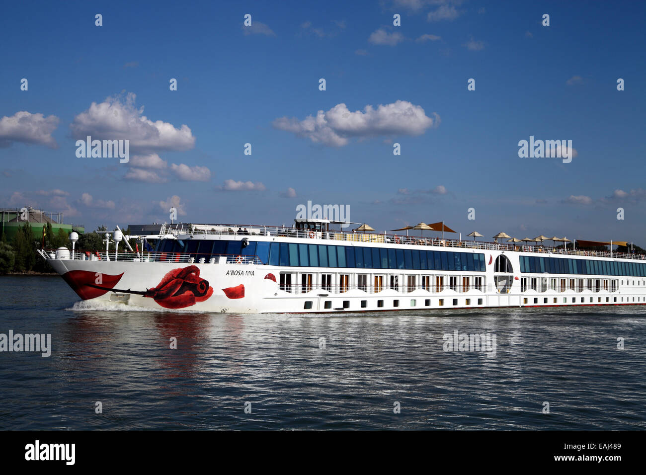 Landscape view of cruise ship on Danube under deep blue sky; red lips and rose decoratioin Stock Photo