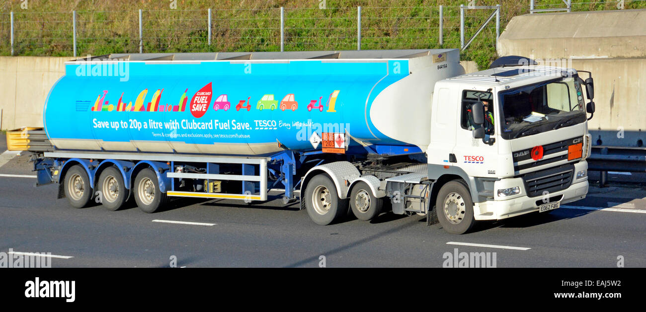 Tesco supermarket articulated petrol tanker trailer behind lorry truck driving along the M25 motorway with advert for clubcard fuel save UK Stock Photo