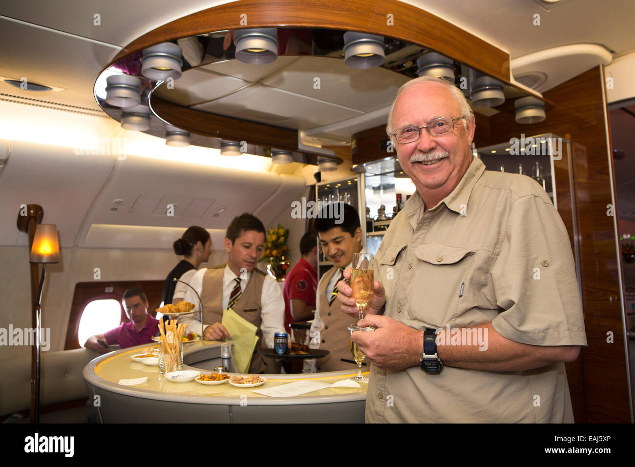 Emirates Airline, male passenger with champagne in bar of A380 Business