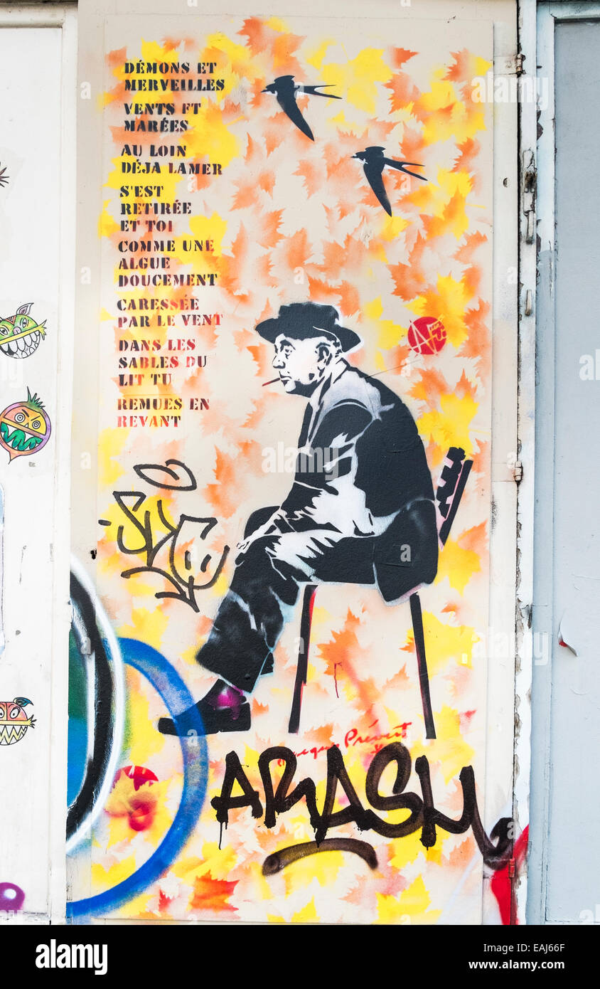 stencil graffito showing french poet jacques prévert sitting on a chair next to the lyrics of the chanson demons et merveilles Stock Photo