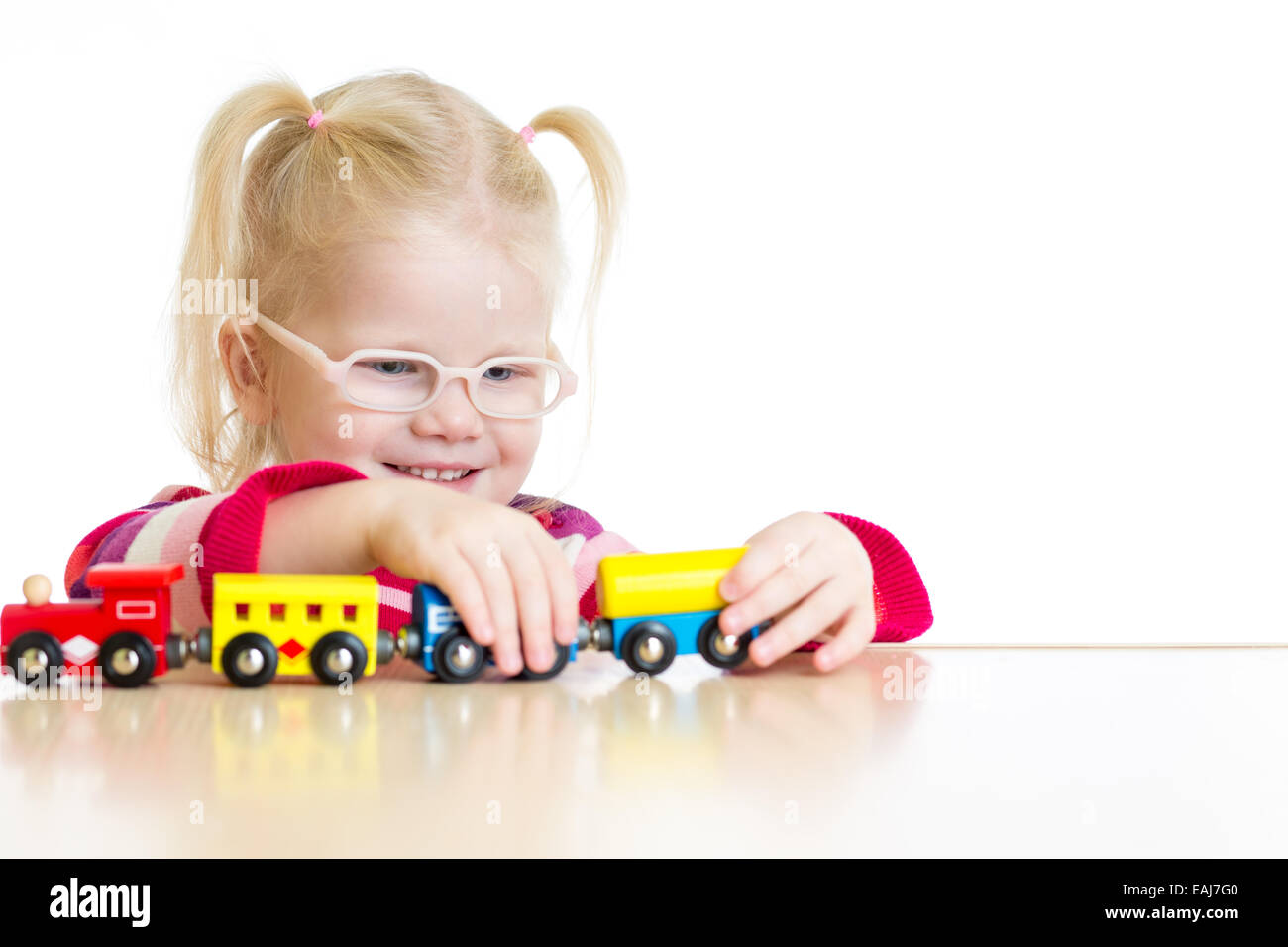 Child in eyeglasses playing toy train isolated Stock Photo
