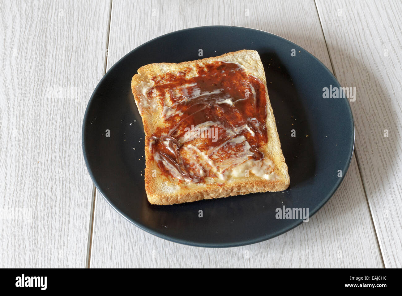 Single piece of hot toast with butter and marmite Stock Photo Alamy