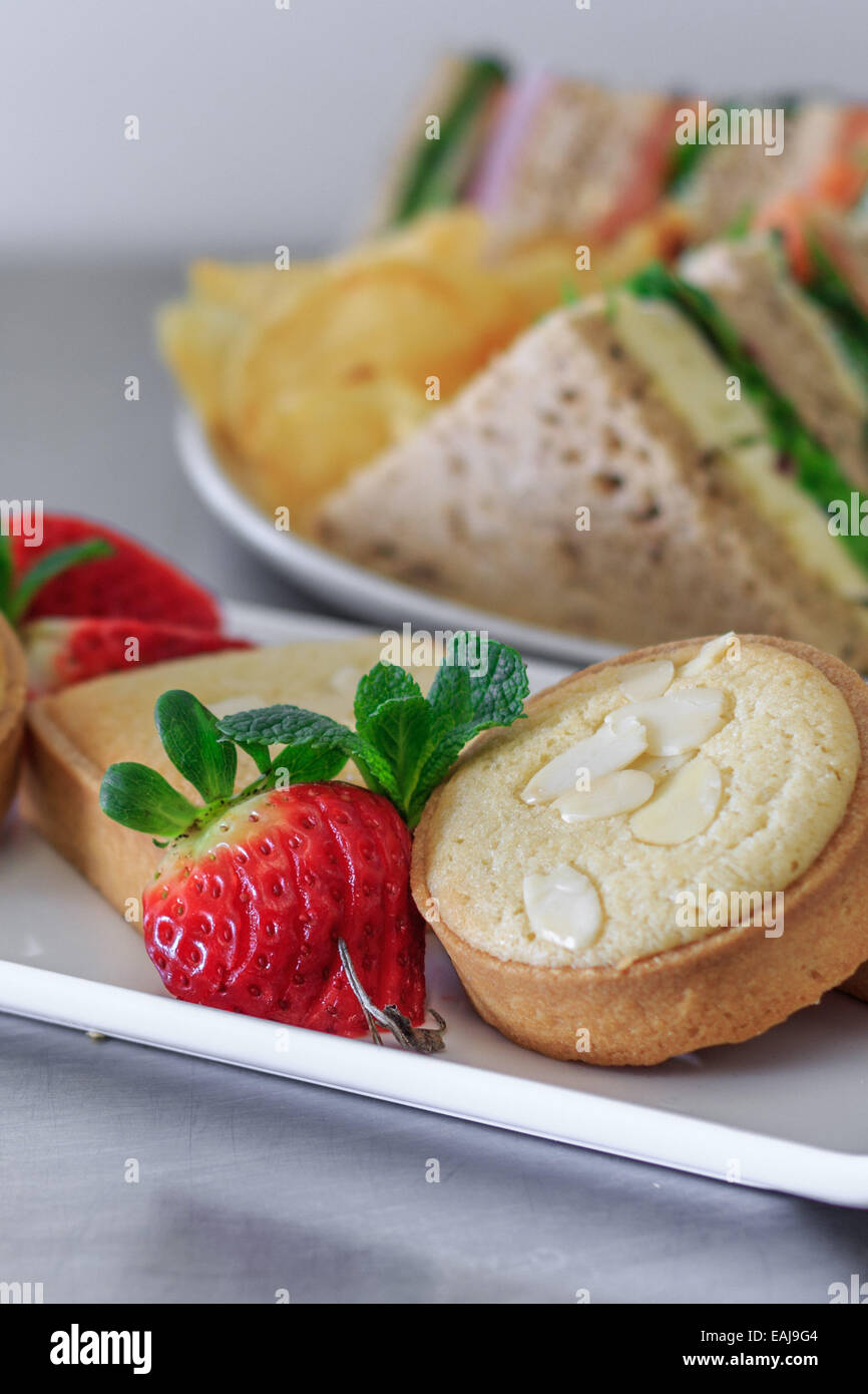 plated buffet lunch with a selection of sandwiches fruit baked sweets and crisps Stock Photo Alamy