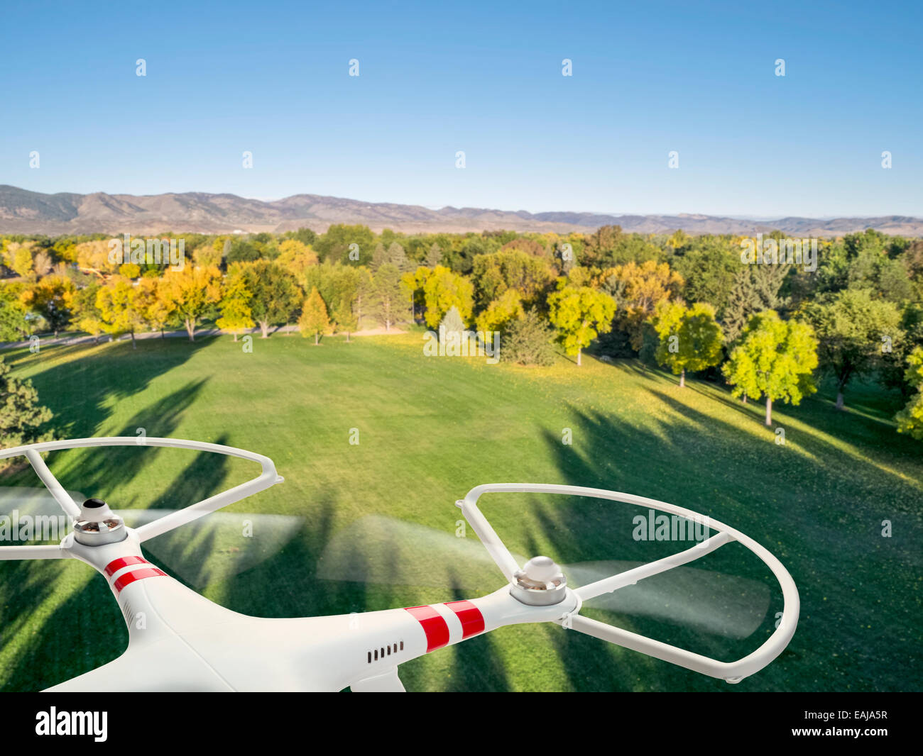 drone flying over park in fall colors under morning light with deep ...