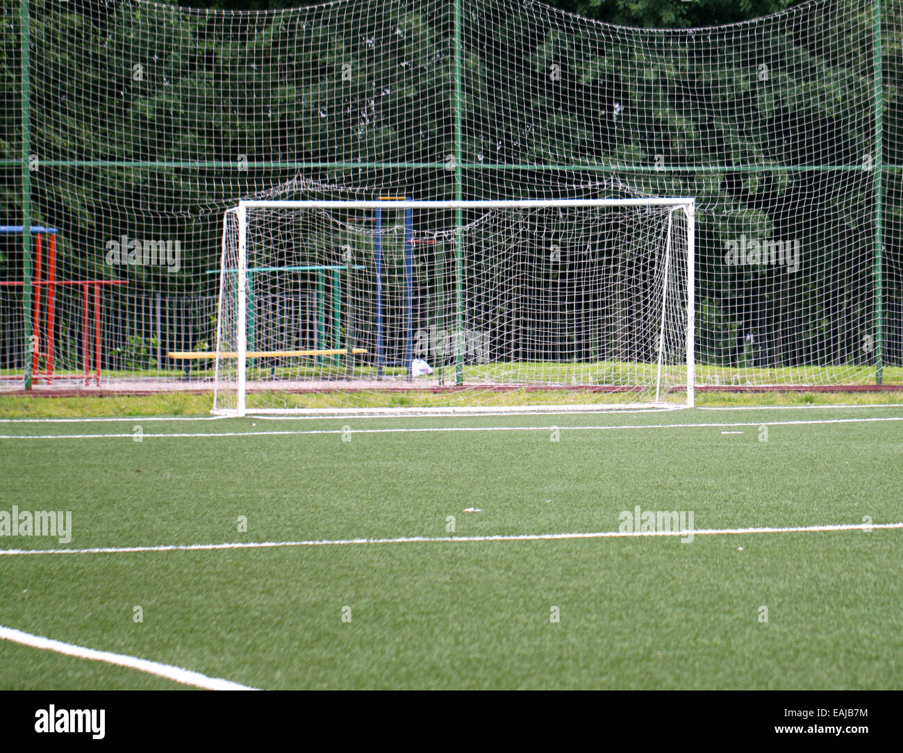 Football goal on a green field on a background of trees Stock Photo