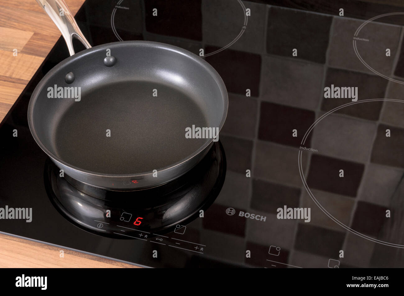 Empty frying pan on an induction hob.Economical electric kitchenware. Stock Photo