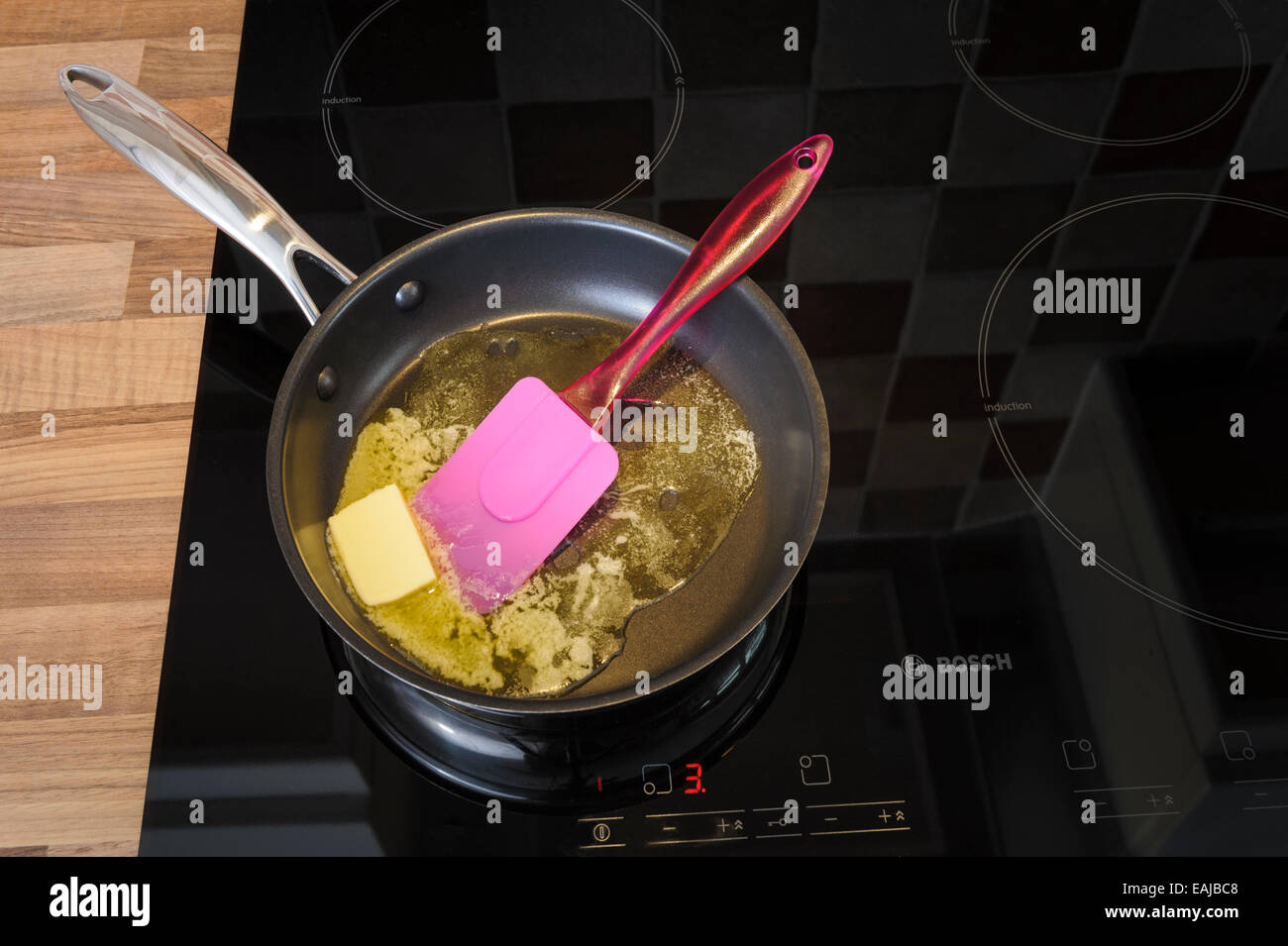 Butter melting in a frying pan, on an induction hob.Unhealthy