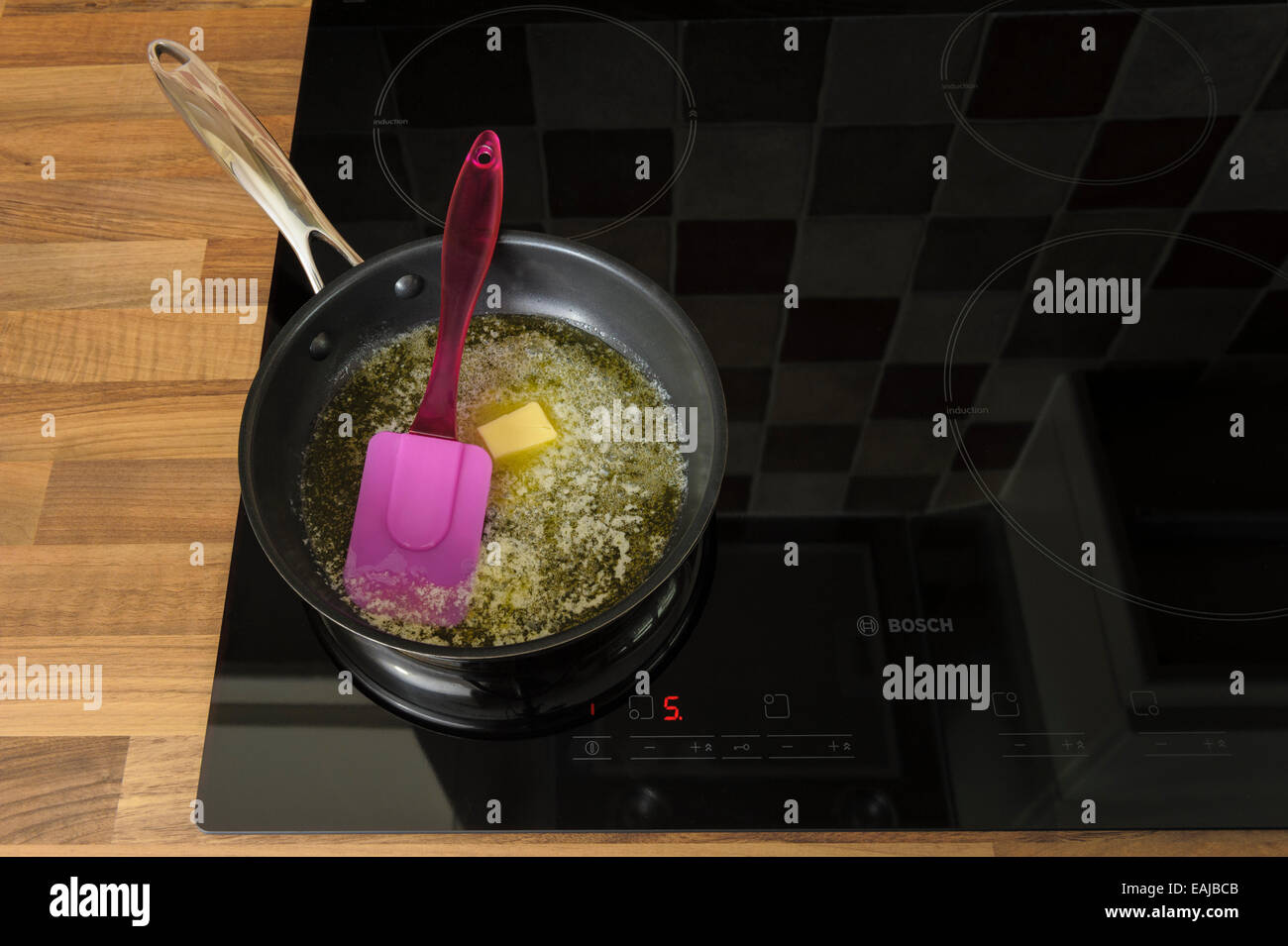 Butter melting in a frying pan, on an induction hob.Unhealthy