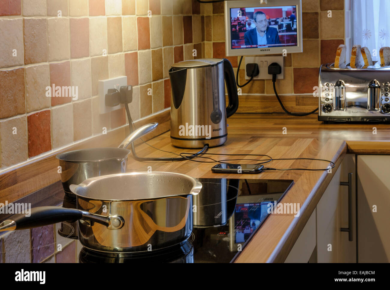 Many appliances being used in a modern kitchen.Heavy electrical consumption. Stock Photo