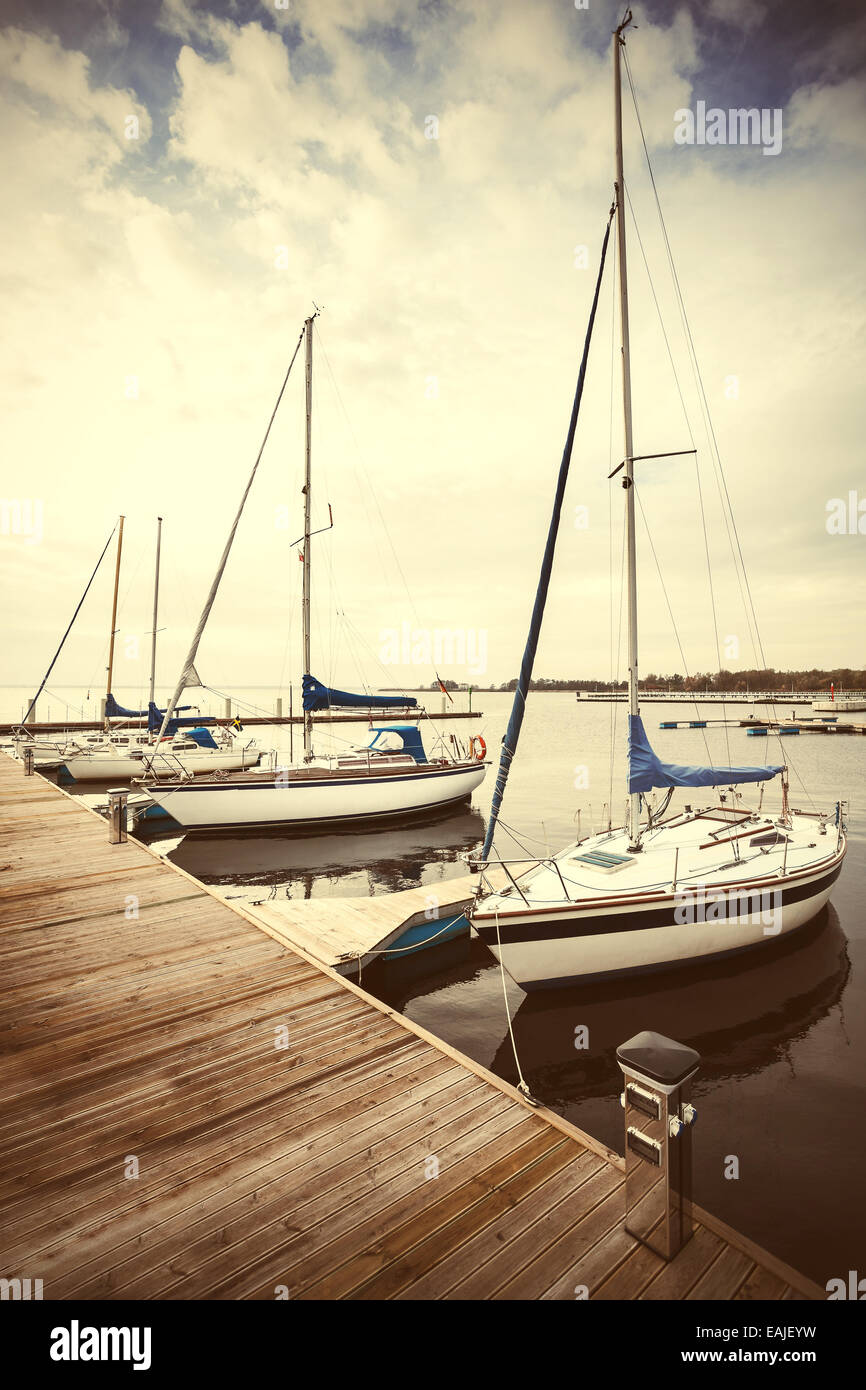 Retro filtered picture of yachts at pier. Stock Photo