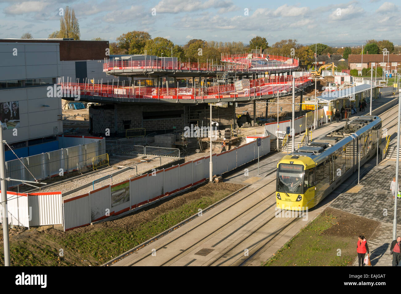 Metrolink tram at the Wythenshawe stop, Airport Line, Manchester, England, UK with new transport interchange under construction. Stock Photo