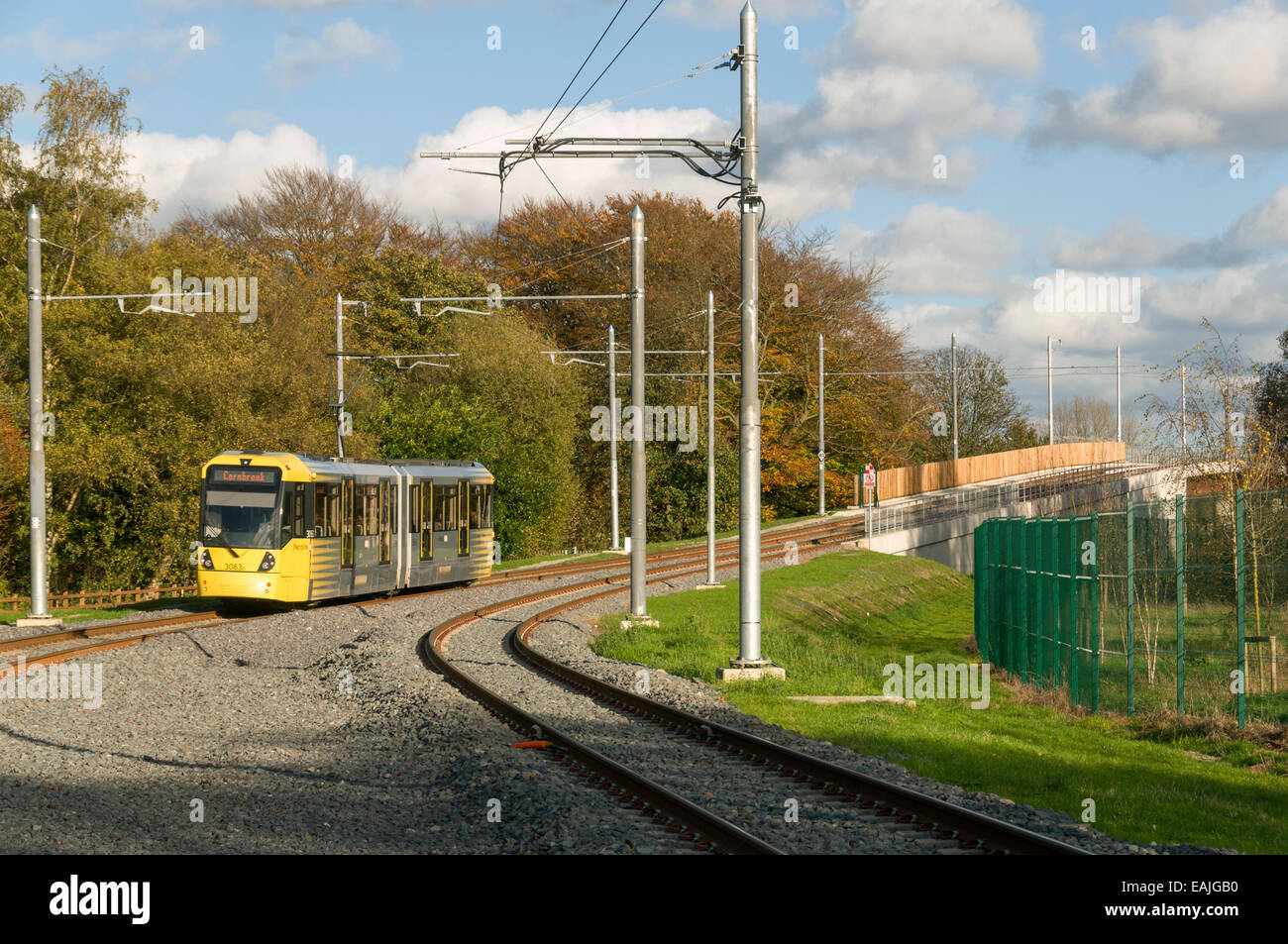 Metrolink tram approaching the river Mersey viaduct near the Sale Water Park stop, Airport Line, Manchester, England, UK Stock Photo