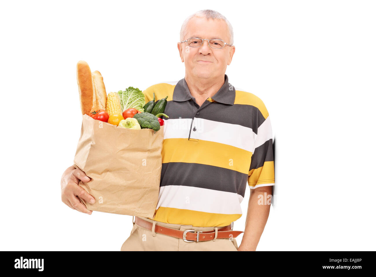 Senior gentleman posing with bag full of groceries isolated on white background Stock Photo
